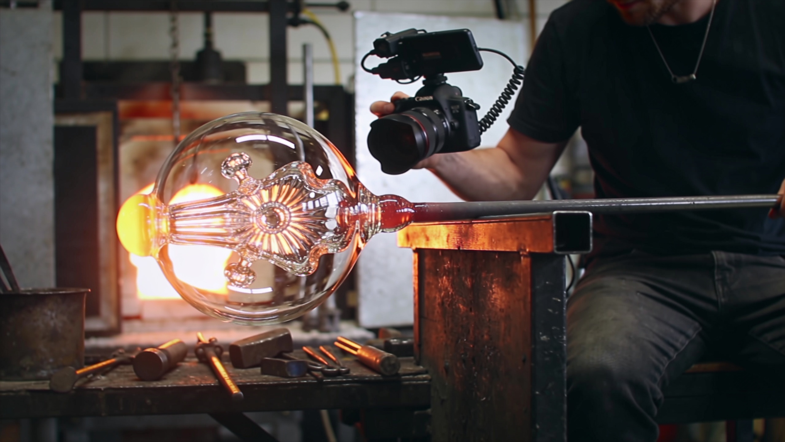 Artisan souffleur de verre créant une œuvre d'art, filmé en gros plan pour un Reel Instagram, avec des effets de lumière dramatiques et une ambiance créative, style cinématographique